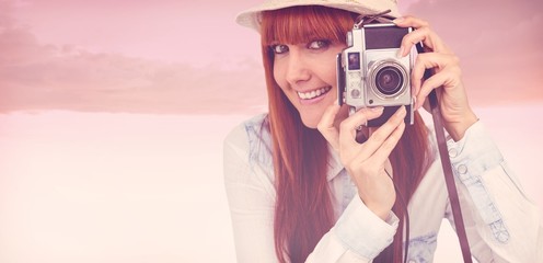 Composite image of attractive hipster photographing with camera