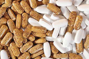White and yellow pills as background