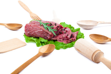 Fresh raw meat and wooden kitchen utensils.