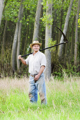  reaper man  with a scythe for mow the grass in the field