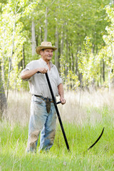  reaper man  with a scythe for mow the grass in the field