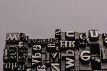 Metal Letterpress Types.
A background from many historic typographical letters in black and white with black background.
