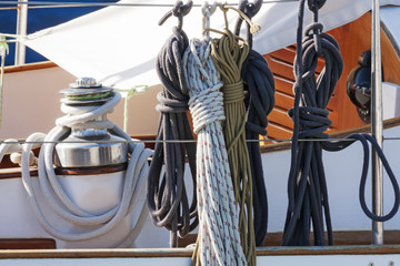 Ropes winch and nautical knots with accessories on a white fiberglass sailboat - obrazy, fototapety, plakaty