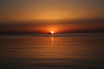 Naklejka premium Sunrise over sea with boat