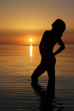 Girl's silhouette in sea sunrise