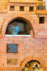 old red brick oven and a pot with food