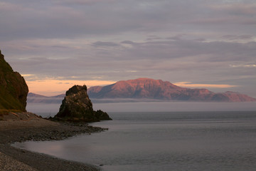 Fototapeta na wymiar Rock at the Cape and the island in the sea. The Sea of Okhotsk. Peninsula Kony. Magadan Region. Russia.