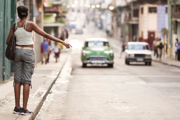 Zelfklevend Fotobehang Young professional woman hitching a taxi in Havana, Cuba. © danmir12