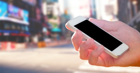 Composite image of hand holding smartphone