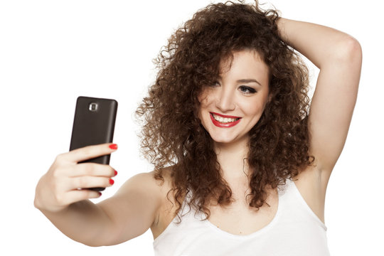 beautiful girl with curly hair takes selfies