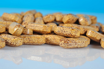 Heap of pills close up on a blue