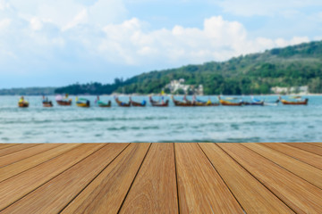 Obraz premium Wood table top on blurred beach background with long tail boat for presentation product.