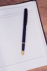 Pen on open book at table
