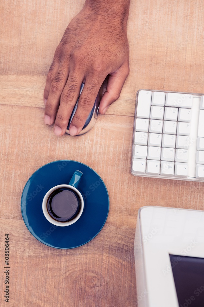Poster businessman using mouse by coffee cup while working