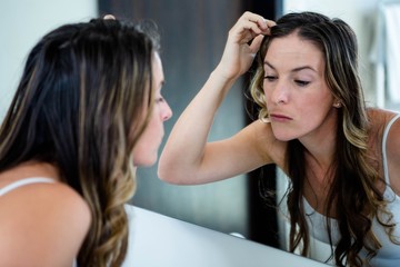 Naklejka premium thoughtful woman looking t her reflection