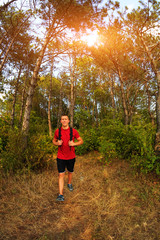 Athletic man with back pack hiking in forest