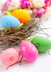Colorful easter eggs in nest on a white background