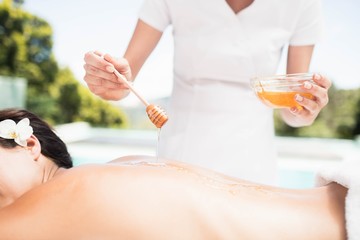Obraz na płótnie Canvas Woman receiving a honey massage from masseur