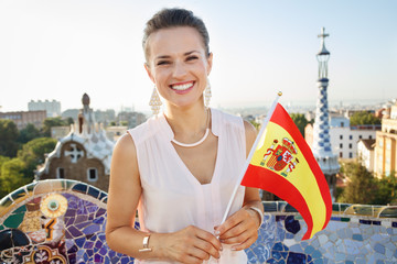Fototapeta premium Woman tourist with Spain flag in Park Guell, Barcelona, Spain