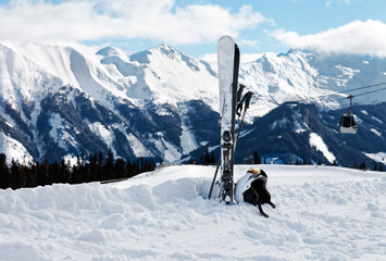 Winter landscape with skis, helmet and goggles and defocused snowy mountains background