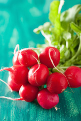 fresh radish with leaves over green background
