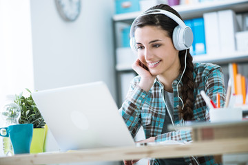 Girl with headphones using a laptop