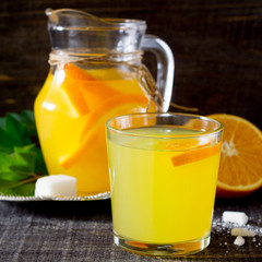 A drink with fresh orange on a wooden table