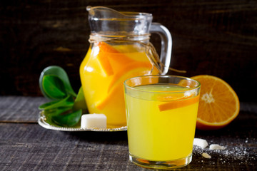 A drink with fresh orange on a wooden table