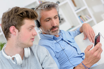 Father and son listening to music on headphones