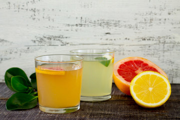 Citrus juices with fresh fruit on wooden table
