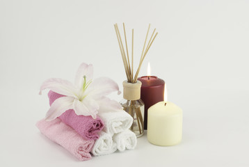 Spa decoration with candles, towels and aromatherapy oil bottle
