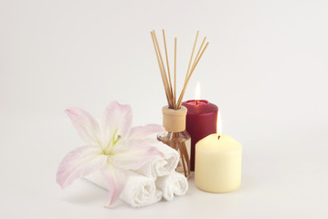 Spa decoration with candles, towels and aromatherapy oil bottle