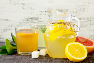 Citrus juices with fresh fruit on wooden table