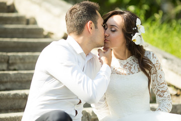 Naklejka premium stylish gorgeous happy brunette bride and elegant groom kissing