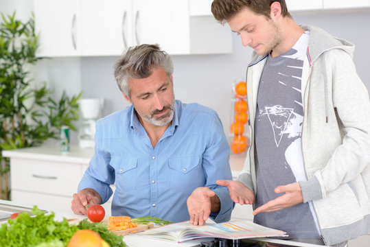 Man chopping vegetables, discussing content of book