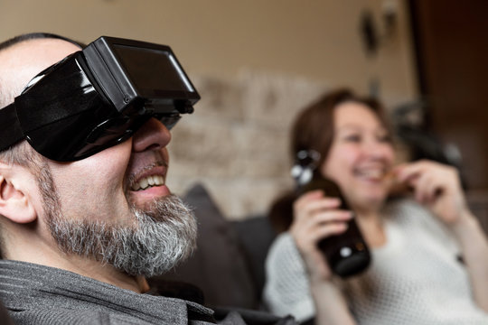 Pärchen zuhause, Mann mit Virtual reality Brille
