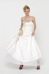 Portrait of gorgeous bride wearing wedding dress over grey backg