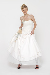 Portrait of gorgeous bride wearing wedding dress over grey backg