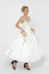 Fototapeta na wymiar Portrait of gorgeous bride wearing wedding dress over grey backg