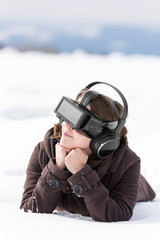 Junge Frau mit einer Virtual reality Brille liegt im Schnee, Sim