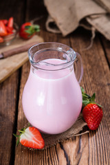 Milk (Strawberry flavoured) on wooden background