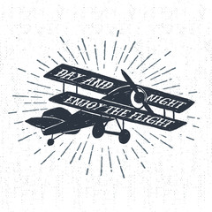 Hand drawn textured vintage label, retro badge with biplane vector illustration and "Day and night - enjoy the flight" lettering. © SlothAstronaut