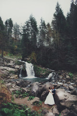 elegant stylish happy brunette bride and gorgeous groom on the b