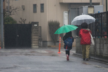 傘をさす親子（雨の日）