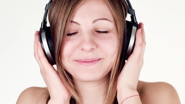 Beautiful And Cheerful woman Listening to Music on headphones and dancing.