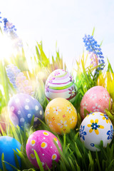 art Colorful Easter eggs on the grass on blue sky background