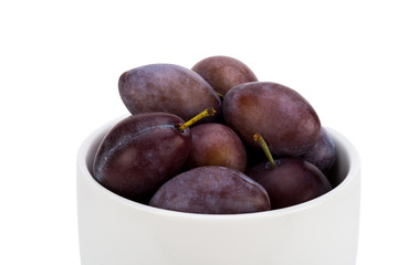 Plums in ceramic bowl - isolated on white background