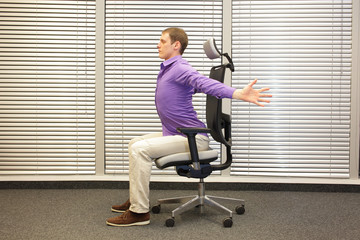 man exercising on chair in office, healthy lifestyle - profile view