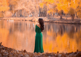 Lady in a luxury lush  emerald dress ,fantastic shot,fairytale princess is walking in the autumn...