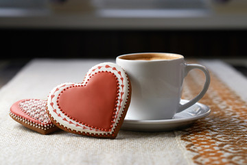 A bit of sweetness. Shot of a Valentine’s day coffee and glazed gingerbread cookie on the table